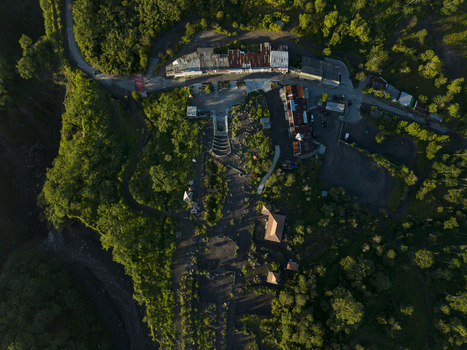 Aerial view of Bunker Kaliadem Merapi surrounded by lush green forests and volcanic landscape under soft morning light in Kecamatan Pakem Daerah Istimewa Yogya Indonesia. Aerial view of Bunker Kaliadem Merapi surrounded by lush green forests and volcanic landscape under soft morning light in Kecamatan Pakem Daerah Istimewa Yogya Indonesia.