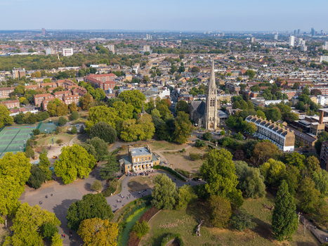 Aerial view of Stoke Newington featuring St Marys Church lush green parkland tennis courts and residential streets in London England United Kingdom. Aerial view of Stoke Newington featuring St Marys Church lush green parkland tennis courts and residential streets in London England United Kingdom.