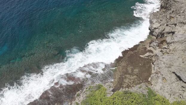 Aerial view of waves crashing on the rocky coast Philippines.