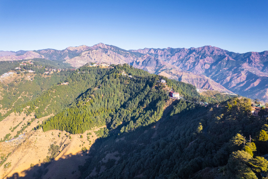 Aerial view of Chakrata hill station featuring lush green mountain ridges and distant peaks under a clear blue sky Chakrata Uttarakhand India. Aerial view of Chakrata hill station featuring lush green mountain ridges and distant peaks under a clear blue sky Chakrata Uttarakhand India.