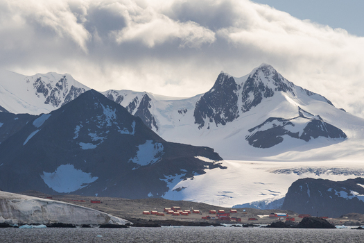 View of the red buildings of the research station set against the dramatic snow covered mountains and glaciers of Esperanza Base Antarctica. View of the red buildings of the research station set against the dramatic snow covered mountains and glaciers of Esperanza Base Antarctica.