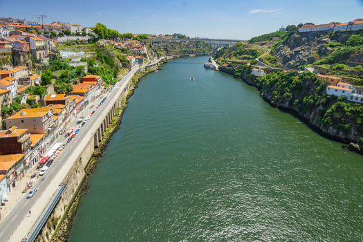 Aerial view of the Douro River snaking through the city terracotta roofs contrasting with the deep green waters Porto Porto District Portugal. Aerial view of the Douro River snaking through the city terracotta roofs contrasting with the deep green waters Porto Porto District Portugal.