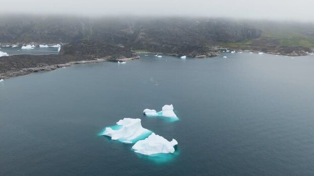 Aerial view of icebergs in a bay near the coast of Greenland. Aerial view of icebergs in a bay near the coast of Greenland.