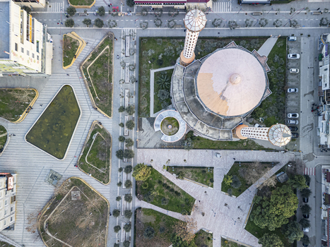 Aerial view of the Fier Mosque with its distinctive dome and minaret surrounded by geometric park walkways and urban infrastructure in Fier Fier County Albania.