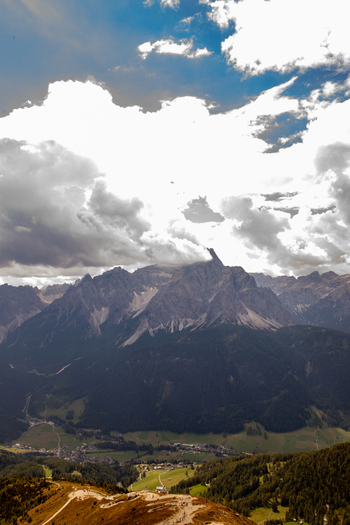 Aerial view of the Dolomites mountain range with dramatic clouds over the peaks and the valley of Rocca Pietore Veneto Italy.