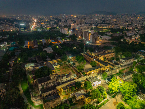 Aerial view of an illuminated historic building complex with stone walls and courtyards surrounded by the city lights of Udaipur Rajasthan India. Aerial view of an illuminated historic building complex with stone walls and courtyards surrounded by the city lights of Udaipur Rajasthan India.