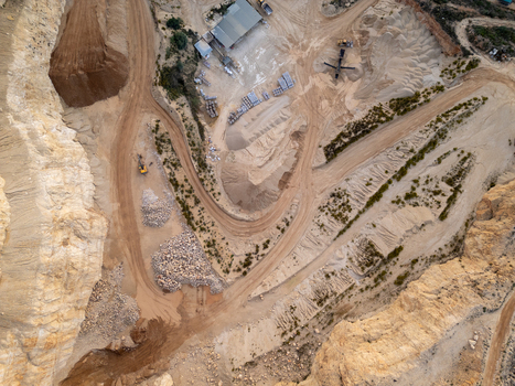 Aerial view of a quarry with piles of sand and gravel heavy machinery and dirt roads in Teulada Valencian Community Spain.