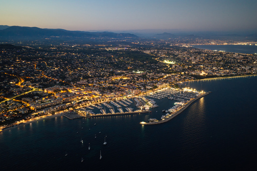 Aerial view of the illuminated marina and city lights of Antibes at night with the Mediterranean coastline along the French Riviera in Antibes Provence Alpes Cote d Azur France. Aerial view of the illuminated marina and city lights of Antibes at night with the Mediterranean coastline along the French Riviera in Antibes Provence Alpes Cote d Azur France.