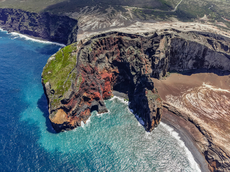 Aerial view of the dramatic Capelinhos Volcano s contrasting red and black rock formations meeting the deep blue sea Capelo A&ccedil;ores Portugal.