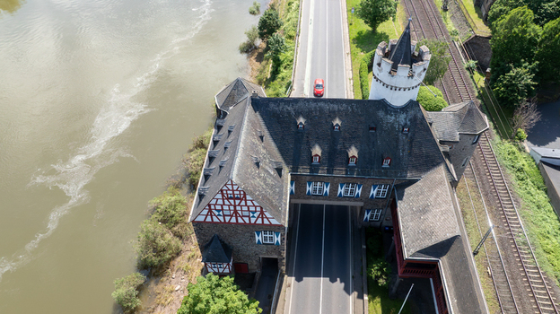 Aerial view of the historic castle gatehouse with a main road passing through the structure next to the river Moselle in Kobern Gondorf Rheinland Pfalz Germany. Aerial view of the historic castle gatehouse with a main road passing through the structure next to the river Moselle in Kobern Gondorf Rheinland Pfalz Germany.