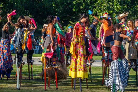 Rio de Janeiro Brazil 20 June 2026 View of performers on stilts in colorful traditional costumes during a Festa Junina celebration in a park with green grass and trees. Rio de Janeiro Brazil 20 June 2026 View of performers on stilts in colorful traditional costumes during a Festa Junina celebration in a park with green grass and trees.