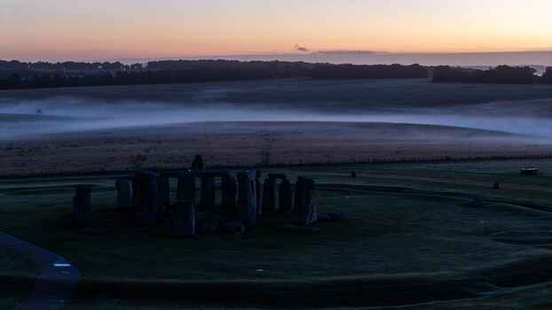 Aerial view of Stonehenge surrounded by misty fields at dawn in Salisbury England United Kingdom. Aerial view of Stonehenge surrounded by misty fields at dawn in Salisbury England United Kingdom.