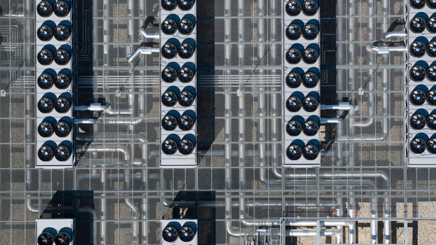 Aerial view of the industrial cooling systems and piping at Switch Datacenters AMS4 with rows of fans on the rooftop in Diemen Noord Holland Netherlands. Aerial view of the industrial cooling systems and piping at Switch Datacenters AMS4 with rows of fans on the rooftop in Diemen Noord Holland Netherlands.