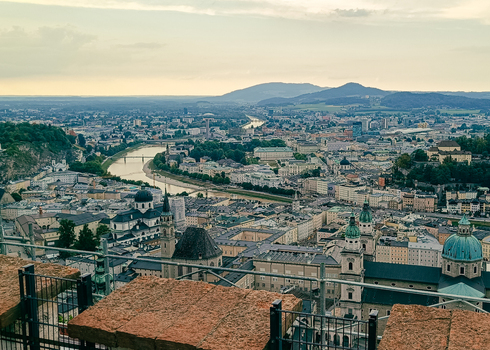 View of the historic city of Salzburg with its iconic cathedral domes the Salzach river winding through the urban landscape and surrounding mountains in Salzburg Salzburg Austria. View of the historic city of Salzburg with its iconic cathedral domes the Salzach river winding through the urban landscape and surrounding mountains in Salzburg Salzburg Austria.