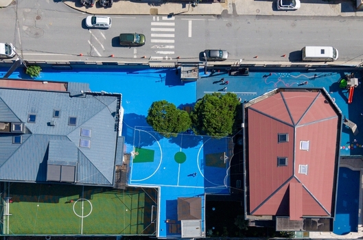 Aerial view of a blue basketball court and a small soccer field nestled between residential buildings in Istanbul Istanbul Turkiye. Aerial view of a blue basketball court and a small soccer field nestled between residential buildings in Istanbul Istanbul Turkiye.