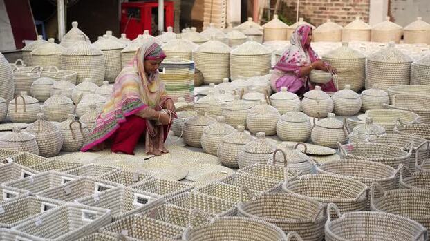 View of women weaving handmade wicker baskets in Bogura Bangladesh. View of women weaving handmade wicker baskets in Bogura Bangladesh.