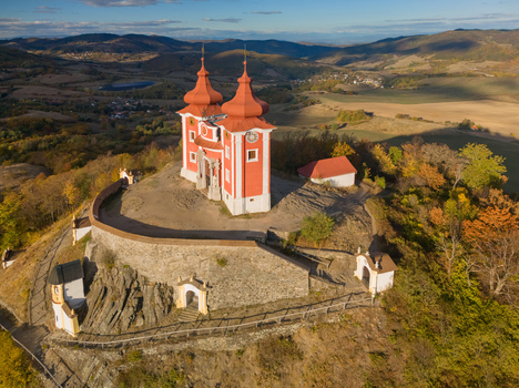Aerial view of the historic Stiavnicka kalvaria a baroque pilgrimage site with red roofed chapels and stone walls set atop a hill in Banska Stiavnica Banskobystricky kraj Slovakia. Aerial view of the historic Stiavnicka kalvaria a baroque pilgrimage site with red roofed chapels and stone walls set atop a hill in Banska Stiavnica Banskobystricky kraj Slovakia.