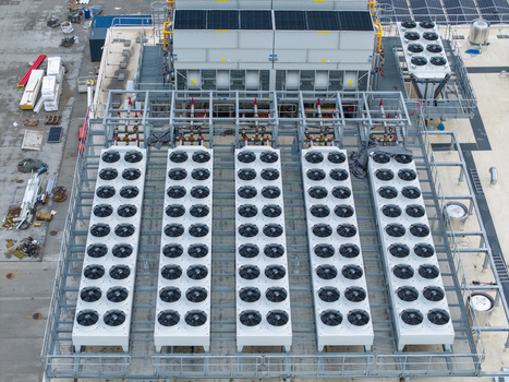Aerial view of an AI data center cooling system with rows of industrial fans and metal piping on a rooftop in Krakow Lesser Poland Voivode Poland. Aerial view of an AI data center cooling system with rows of industrial fans and metal piping on a rooftop in Krakow Lesser Poland Voivode Poland.