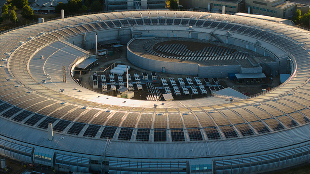 Aerial view of Diamond Light Source a circular synchrotron facility surrounded by greenery under golden hour light in Didcot United Kingdom.