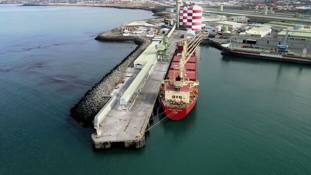 Aerial view of a large cargo ship docked at the industrial port Iceland.