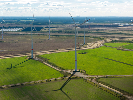 Aerial view of wind turbines at Windpark Forst Briesnig II on recultivated land of the former Janschwalde open pit mine with green fields and long shadows in Forst Brandenburg Germany. Aerial view of wind turbines at Windpark Forst Briesnig II on recultivated land of the former Janschwalde open pit mine with green fields and long shadows in Forst Brandenburg Germany.