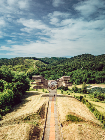 Aerial view of the Monument to the Revolution of the People of Moslavina on a grassy hill surrounded by forests in Podgaric Bjelovarsko bilogorsk Croatia.