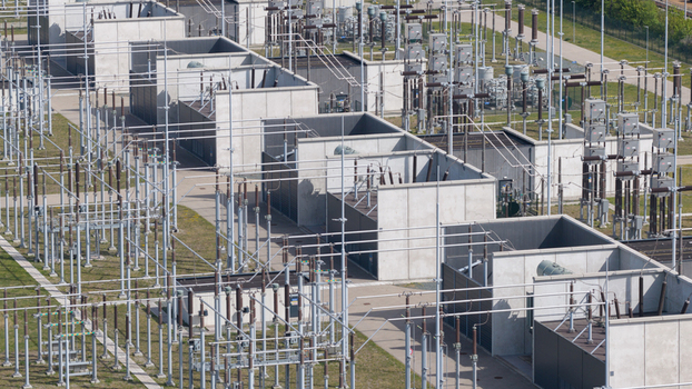 Aerial view of an electrical substation featuring concrete enclosures and high voltage power lines under bright daylight in Velsen Noord North Holland Netherlands.