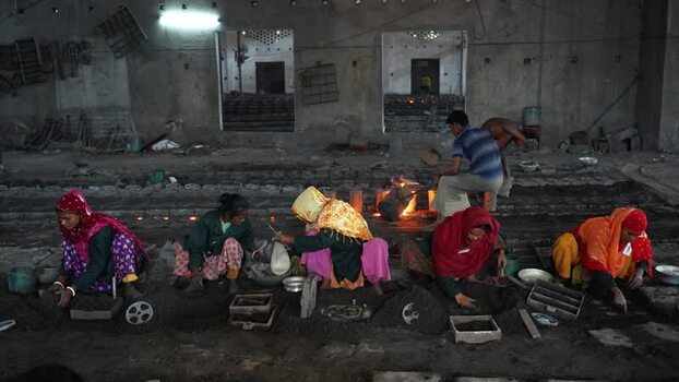 View of women working in a traditional metal foundry in Bangladesh.