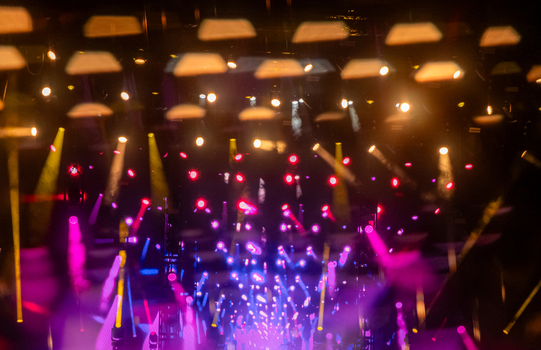 View of vibrant stage lighting with purple blue and yellow spotlights creating a bokeh effect at an event in Nyon Vaud Switzerland.