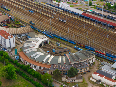 Aerial view of a historic railway roundhouse with a turntable and locomotives on tracks at a busy train depot in Breclav South Moravian Region Czechia.