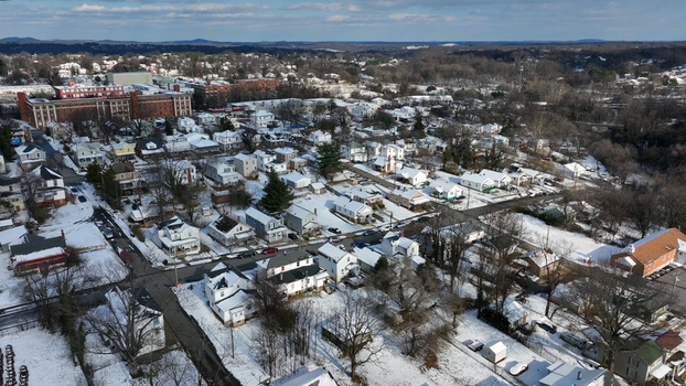 Aerial view of a snow covered residential neighborhood with houses streets and bare trees in Lynchburg Virginia United States.