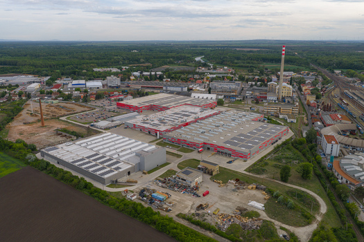 Aerial view of a large industrial complex with modern warehouses solar panels and a tall chimney near railway tracks in Breclav South Moravian Region Czechia.