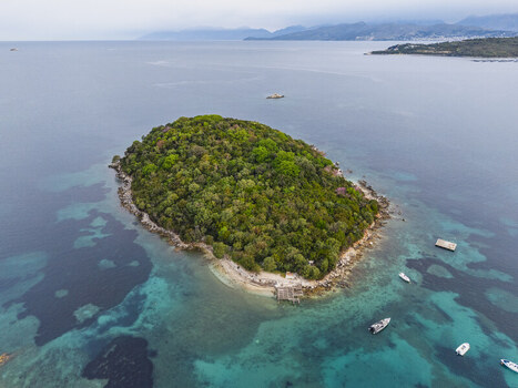 Aerial view of the lush green Ksamil islands surrounded by turquoise waters and small boats in Ksamil Vlore County Albania. Aerial view of the lush green Ksamil islands surrounded by turquoise waters and small boats in Ksamil Vlore County Albania.