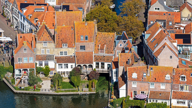 Aerial view of historic brick houses with orange tiled roofs lining a canal in the town of Enkhuizen North Holland Netherlands. Aerial view of historic brick houses with orange tiled roofs lining a canal in the town of Enkhuizen North Holland Netherlands.