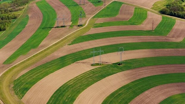 Aerial view of striped fields and power lines in Brno Czechia.