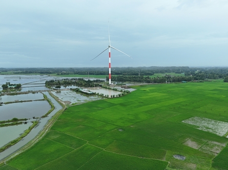 Aerial view of the Khurushkul wind turbine standing amidst lush green rice paddies and water filled aquaculture ponds in Cox s Bazar Chittagong Division Bangladesh. Aerial view of the Khurushkul wind turbine standing amidst lush green rice paddies and water filled aquaculture ponds in Cox s Bazar Chittagong Division Bangladesh.