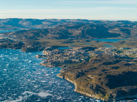 Aerial view of Ilulissat glacier with icebergs floating in the water near the coastal town of Ilulissat Greenland. Aerial view of Ilulissat glacier with icebergs floating in the water near the coastal town of Ilulissat Greenland.