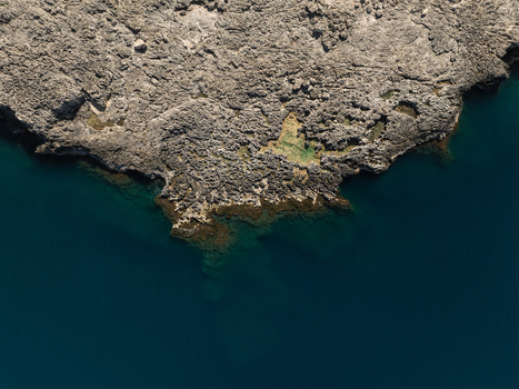 Aerial view of the rugged rocky coastline of the Plemmirio Marine Protected Area with jagged cliffs and deep blue Mediterranean waters in Plemmirio Sicily Italy. Aerial view of the rugged rocky coastline of the Plemmirio Marine Protected Area with jagged cliffs and deep blue Mediterranean waters in Plemmirio Sicily Italy.