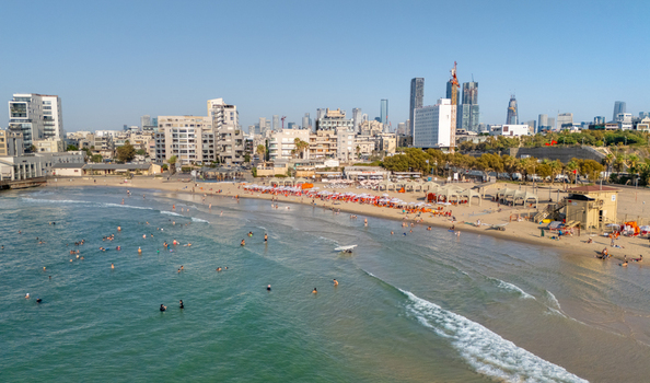 Aerial view of the sandy beach in Tel Aviv Yafo with people swimming sunbathing under umbrellas and the modern city skyline Tel Aviv Yafo Tel Aviv District Israel. Aerial view of the sandy beach in Tel Aviv Yafo with people swimming sunbathing under umbrellas and the modern city skyline Tel Aviv Yafo Tel Aviv District Israel.