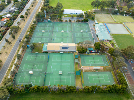 Aerial view of Sorrento Tennis Club featuring multiple green tennis courts surrounding trees and adjacent parking areas in Duncraig Western Australia Australia. Aerial view of Sorrento Tennis Club featuring multiple green tennis courts surrounding trees and adjacent parking areas in Duncraig Western Australia Australia.