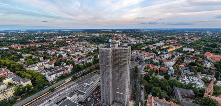 Aerial view of Steglitzer Kreisel skyscraper under renovation surrounded by urban cityscape railway tracks and lush green trees in Berlin Berlin Germany. Aerial view of Steglitzer Kreisel skyscraper under renovation surrounded by urban cityscape railway tracks and lush green trees in Berlin Berlin Germany.