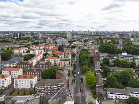 Aerial view of Shoreditch featuring dense urban architecture residential apartment blocks with red tiled roofs tree lined streets and a city skyline in London England United Kingdom. Aerial view of Shoreditch featuring dense urban architecture residential apartment blocks with red tiled roofs tree lined streets and a city skyline in London England United Kingdom.