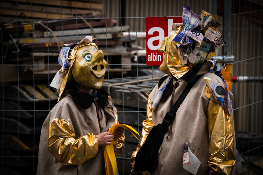 Basel Switzerland 10 March 2025 View of two masked figures one with a pig like visage adorned in gold standing against a backdrop of urban scaffolding and the albin sign. Basel Switzerland 10 March 2025 View of two masked figures one with a pig like visage adorned in gold standing against a backdrop of urban scaffolding and the albin sign.