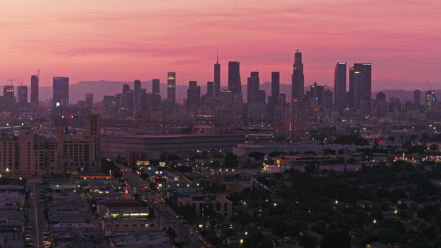 Aerial view of the Los Angeles skyline at sunset with vibrant pink clouds over the skyscrapers and urban landscape in Los Angeles California United States.