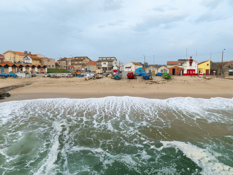 Aerial view of vibrant beach huts nestled along the sandy shore contrasting with the turbulent ocean waves Vila Chã Porto Portugal. Aerial view of vibrant beach huts nestled along the sandy shore contrasting with the turbulent ocean waves Vila Chã Porto Portugal.