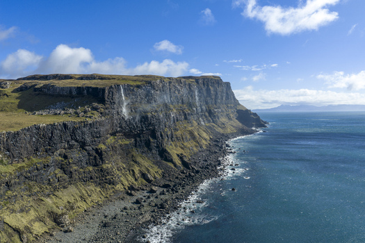 Aerial view of the dramatic cliffs and rocky shoreline of Talisker Bay Beach meeting the turquoise waters of the Atlantic Ocean Isle of Skye Scotland United Kingdom. Aerial view of the dramatic cliffs and rocky shoreline of Talisker Bay Beach meeting the turquoise waters of the Atlantic Ocean Isle of Skye Scotland United Kingdom.