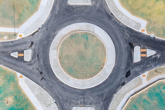 Aerial view of a newly constructed roundabout in a residential development area with asphalt roads and concrete curbs in Perth Western Australia Australia. Aerial view of a newly constructed roundabout in a residential development area with asphalt roads and concrete curbs in Perth Western Australia Australia.