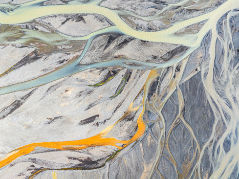 Aerial view of a complex braided river system with glacial meltwater and colorful mineral deposits flowing through the volcanic landscape of Iceland. Aerial view of a complex braided river system with glacial meltwater and colorful mineral deposits flowing through the volcanic landscape of Iceland.