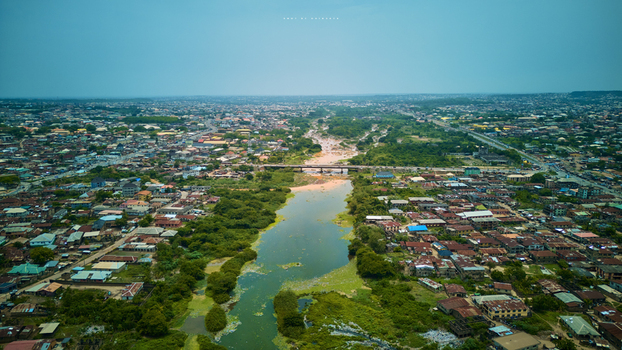 Aerial view of a vibrant cityscape bisected by a winding river under a hazy sky the bridge connecting both sides Abeokuta Ogun State Nigeria.