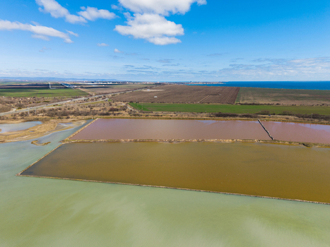 Aerial view of the colorful salt evaporation ponds of Lake Atanasovsko with surrounding fields and the Black Sea coast in Burgas Burgas Bulgaria. Aerial view of the colorful salt evaporation ponds of Lake Atanasovsko with surrounding fields and the Black Sea coast in Burgas Burgas Bulgaria.
